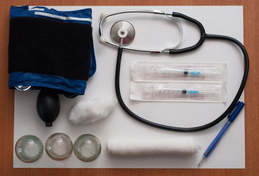 image of medical tools on a table including gauze, needles, and stethoscope